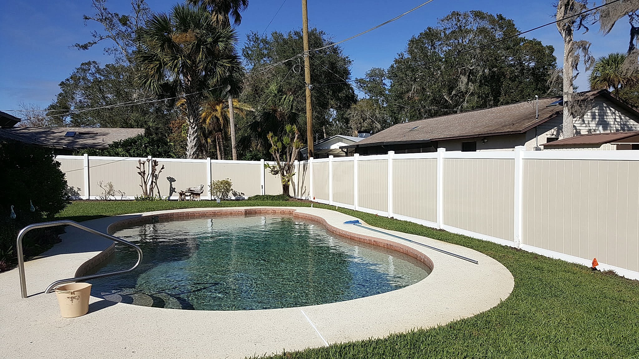 two color vinyl fencing around a pool Residential Fence Installation around a pool in ocala florida.
